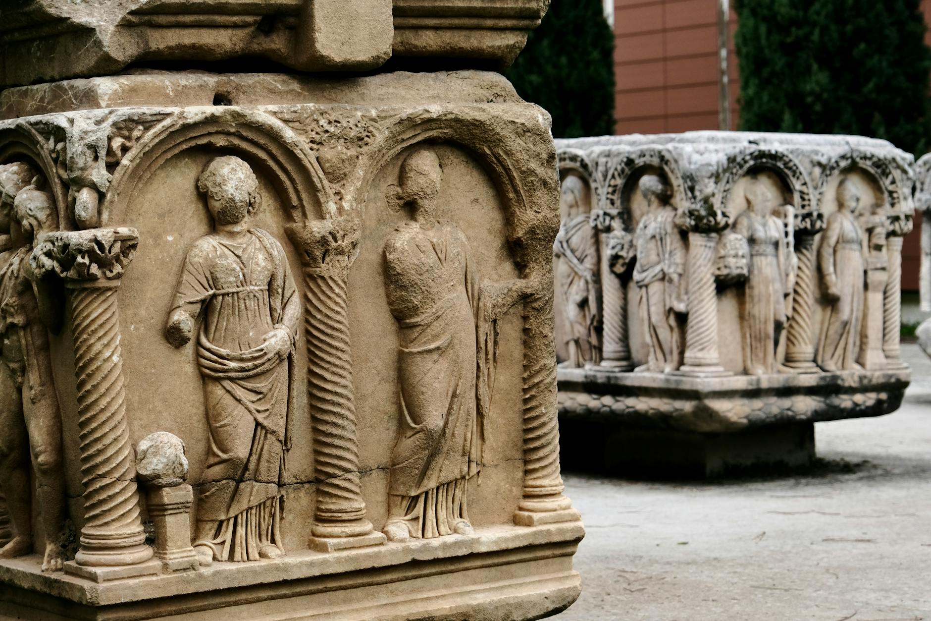 Kamienne rzeźby postaci na historycznej fasadzie na świeżym powietrzu