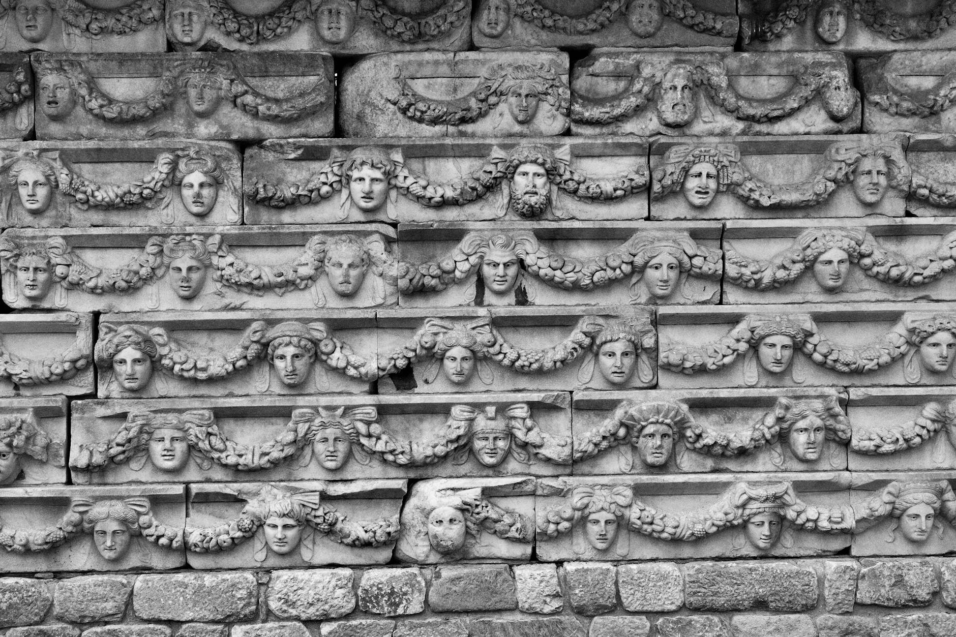 Kamienny fryz z twarzami starożytnych Greków i girlandami