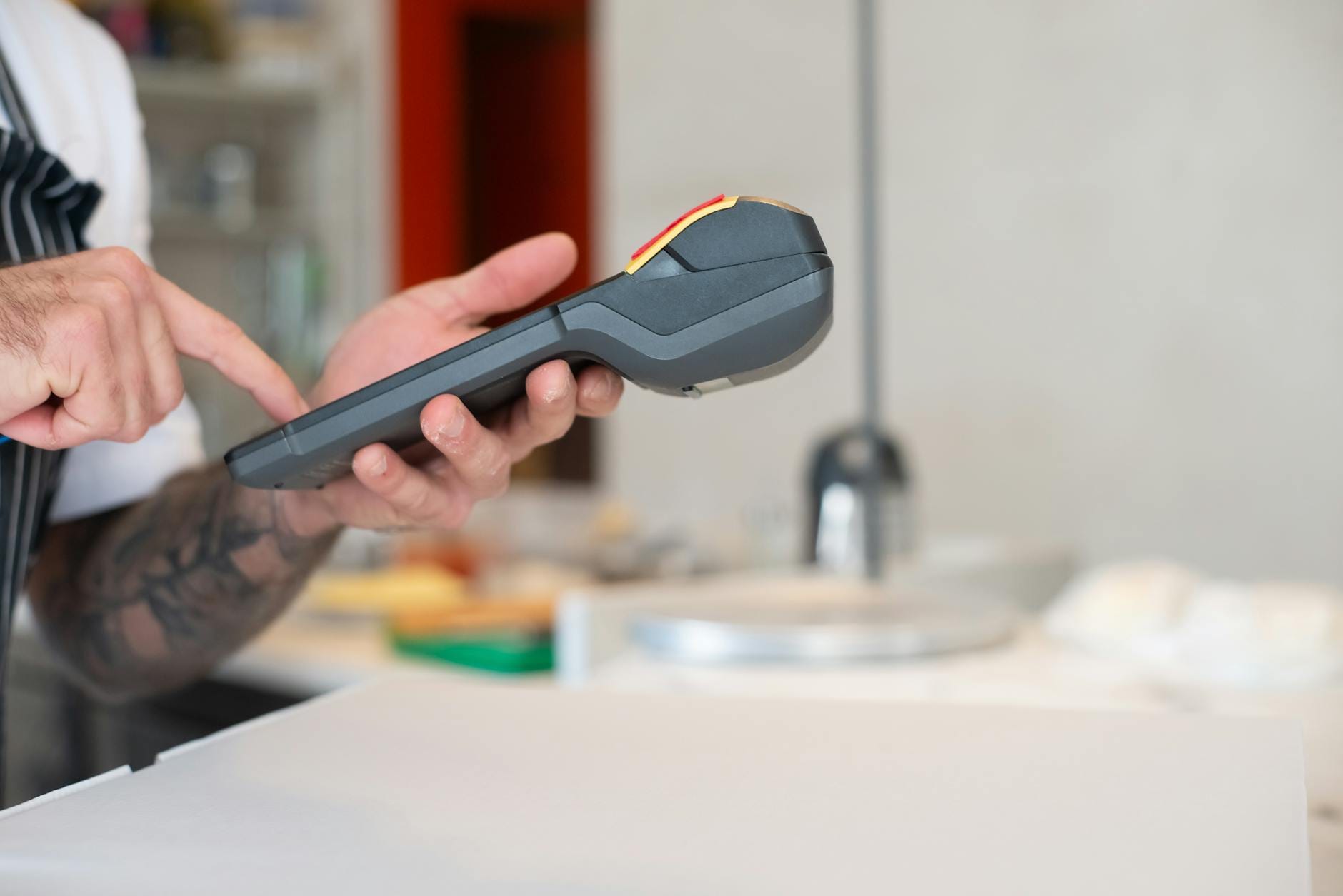 Kelnerka kasuje rachunek na bezprzewodowym terminalu w restauracji