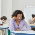 Jak pracować z uczniem, który boi się matematyki i blokuje się przy sprawdzianach? Konkretne kroki Uczniowie piszą sprawdzian z matematyki w szkolnej sali