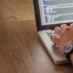 Zbliżenie na osobę programującą wzory matematyczne na laptopie