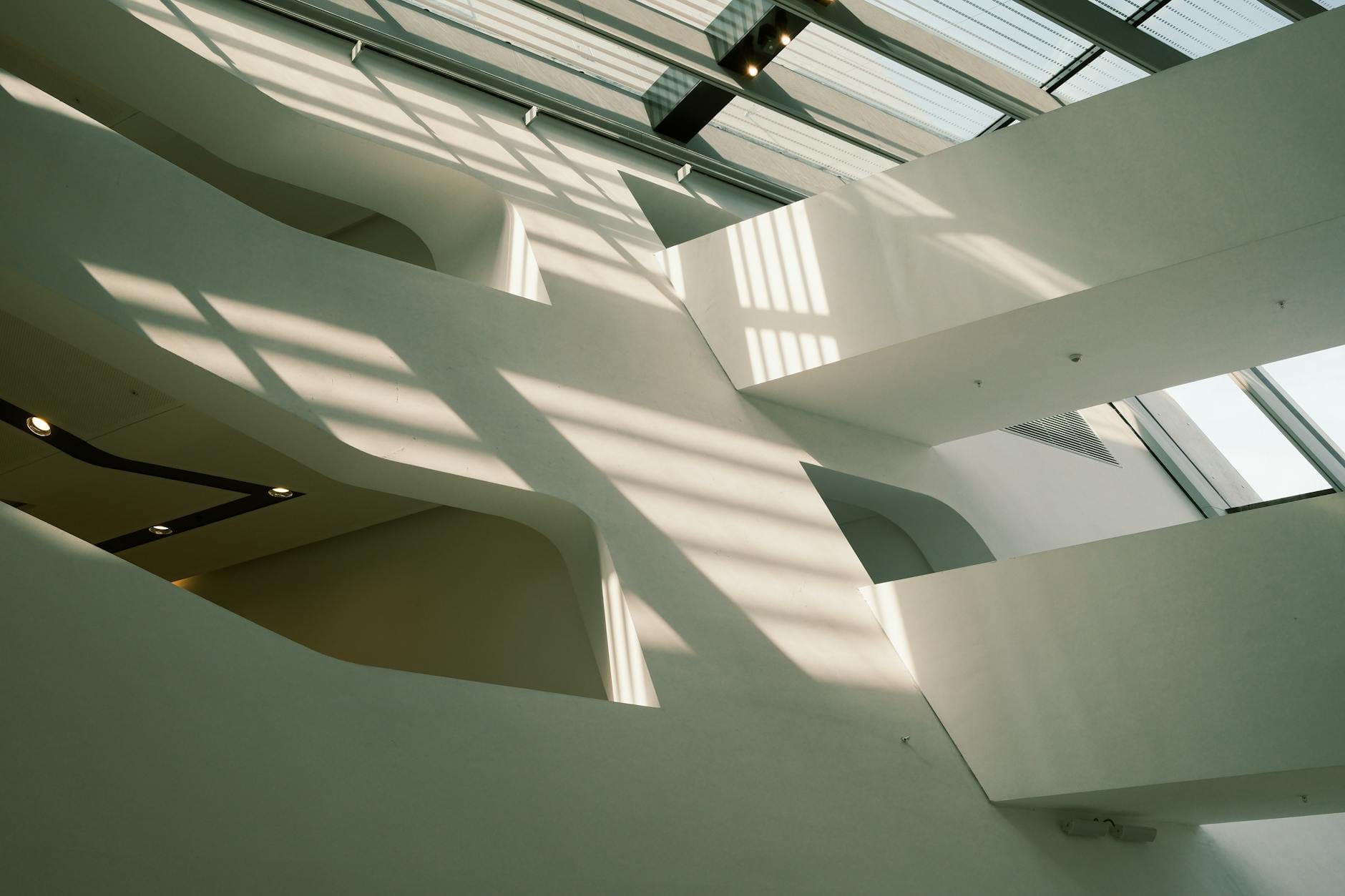 Minimalistyczne wnętrze z świetlikami i geometrycznymi cieniami