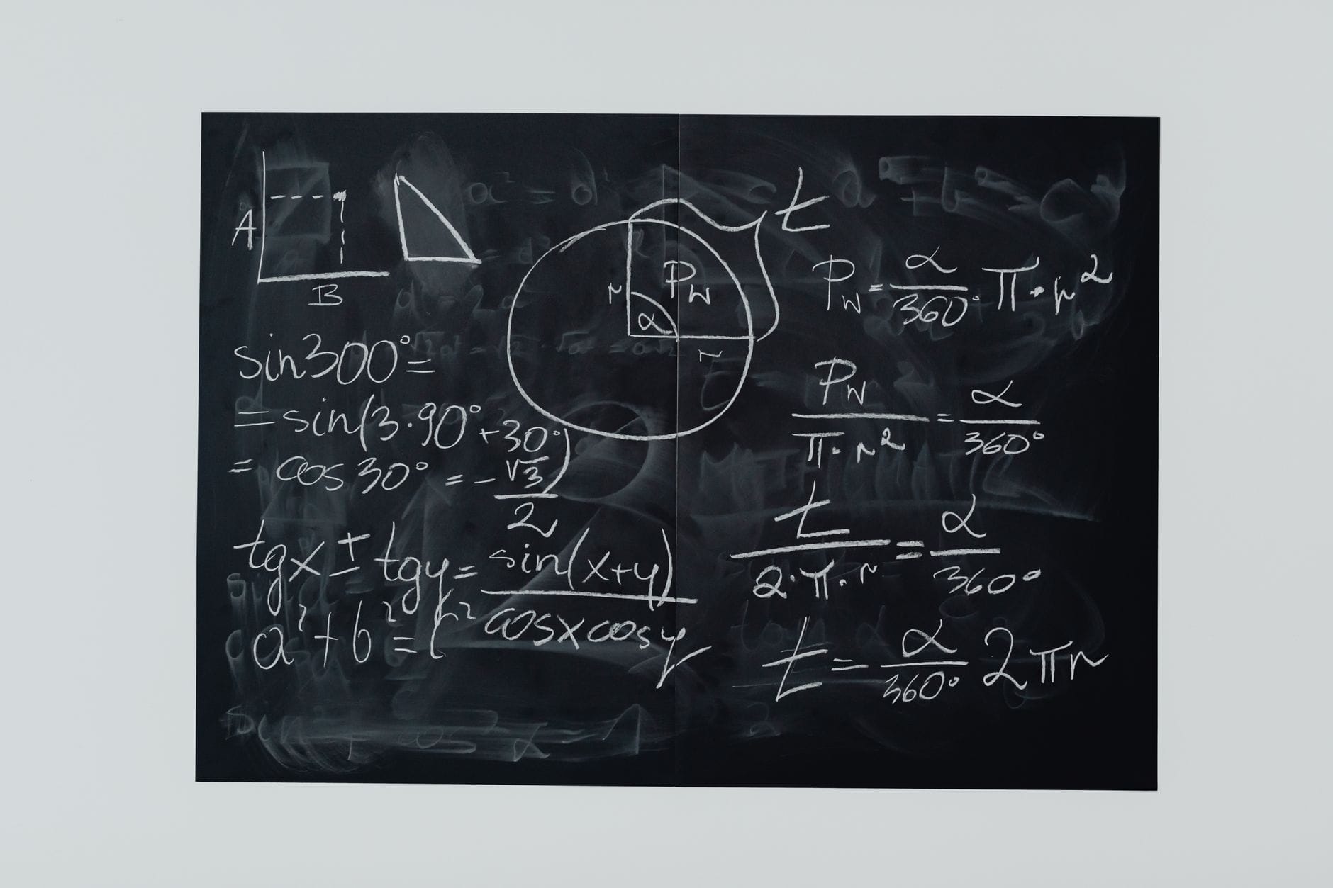 Wzory i rysunki geometryczne na czarnej tablicy szkolnej