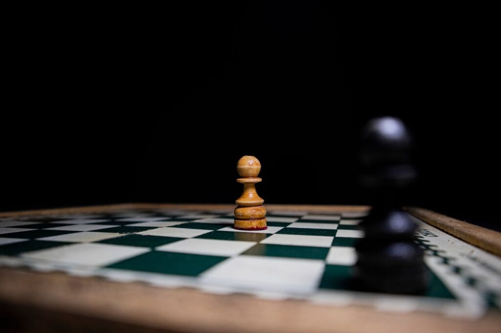 Figury szachowe na planszy symbolizujące strategiczne decyzje w teorii gier